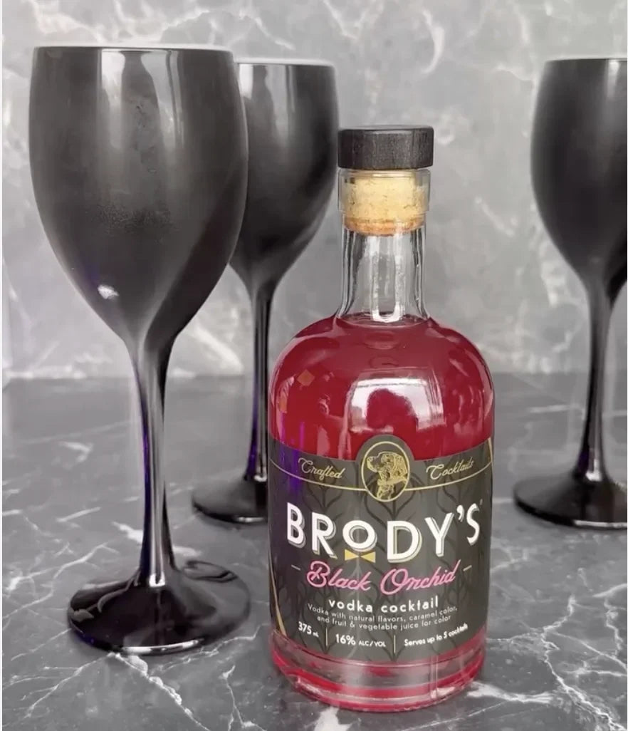 Brody's Black Orchid vodka cocktail with black wine goblets on dark marble for a Halloween party
